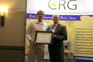 Caroga Arts Collective founder Kyle Price, left, is presented with the Start-up Business Award by Fulton County Center for Regional Growth President Ron Peters